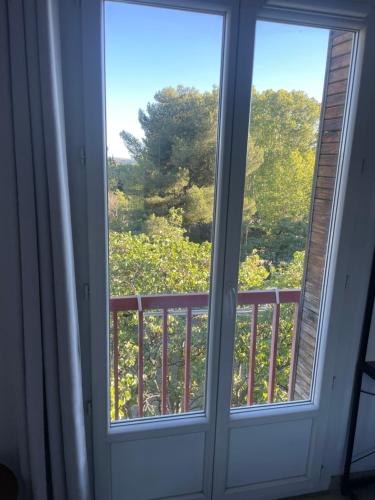 une fenêtre avec vue sur un champ d'arbres dans l'établissement Chambre privée, à Aix-en-Provence