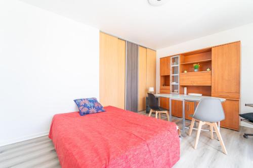 - une chambre avec un lit rouge et un bureau dans l'établissement Résidence Gabrielle - Proche de Paris, à Bondy