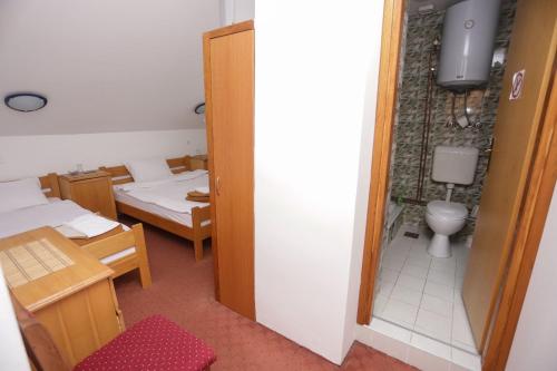 ein Zimmer mit einem Zimmer mit zwei Betten und einer Toilette in der Unterkunft Restora Točak Mokro Rooms in Mokro