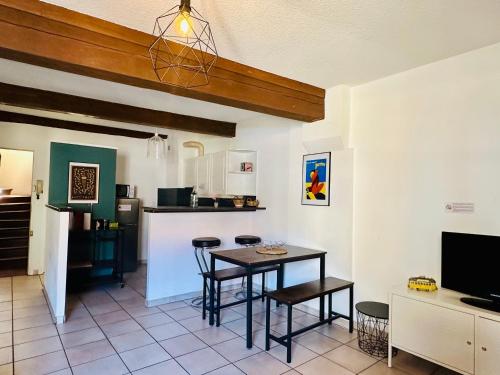 une cuisine avec une table et des chaises dans une pièce dans l'établissement COSY CENTRAL - Charme au Centre - Wifi, à Perpignan