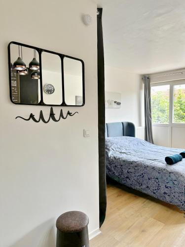 une chambre avec un lit et un miroir au mur dans l'établissement Appartement élégant et cosy - 4Pers, à Juvisy-sur-Orge