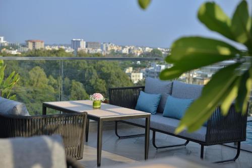 a patio with a table and blue pillows on a balcony at Treat Hotel Nashik City Center in Nashik