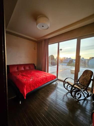 a bedroom with a red bed and a chair at Retro Villa in Batumi