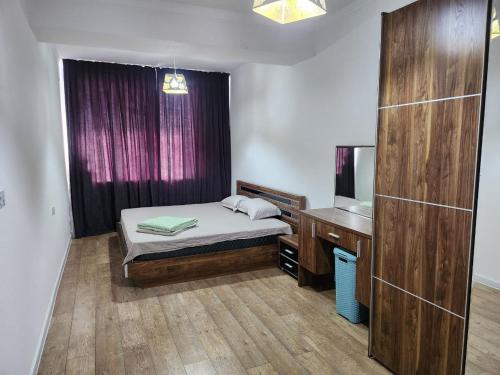 une chambre avec un lit et un bureau avec un miroir dans l'établissement Greenwich, à Tachkent