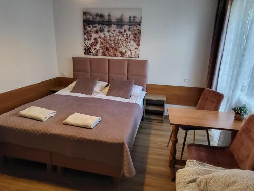 a bedroom with a bed with two pillows on it at Pokoje Gościnne u MARCINA- sala zabaw, basen, melex, rowery, grill in Ostrowo