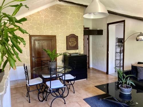 un salon avec une table en verre et des chaises dans l'établissement charmant appartement dans joli village d’Annot, à Annot