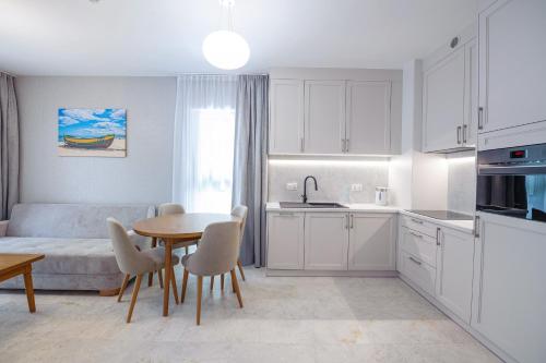 a kitchen and living room with a table and a couch at Apartamenty Akwamaryn in Ustka