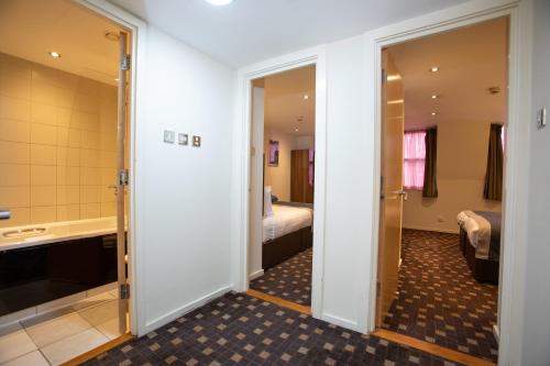 a hotel room with a bathroom and a bedroom at Grand Plaza Serviced Apartments in London