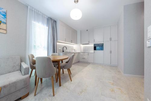 a kitchen and dining room with a table and chairs at Apartamenty Akwamaryn in Ustka