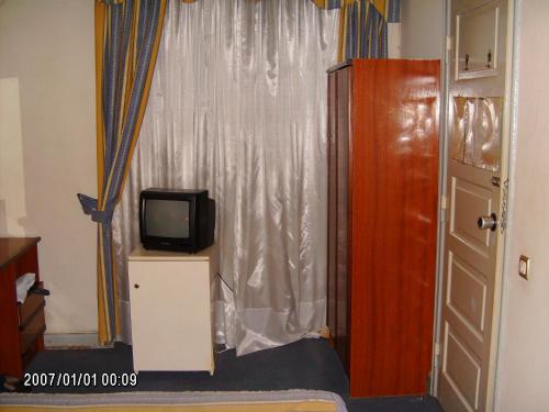 Habitación con TV pequeña y ventana. en Olhos Pretos, en Caldas da Rainha