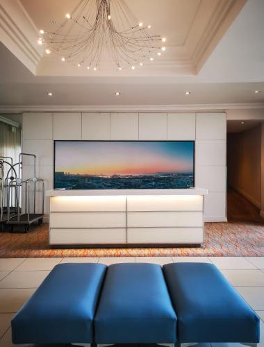 a living room with a blue couch and a tv at Garden Court Nelson Mandela Boulevard in Cape Town