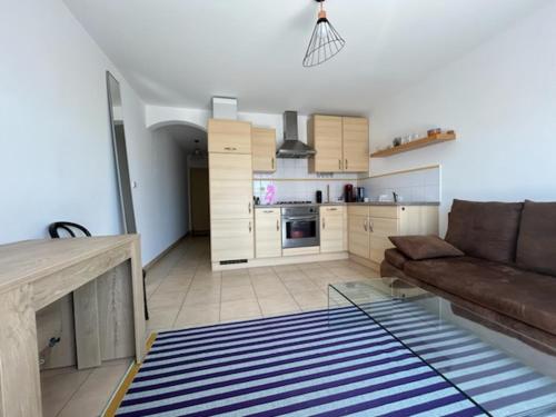 un salon avec un canapé et une cuisine dans l'établissement T2 domino, à Hyères