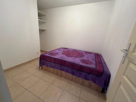 une chambre avec un lit dans le coin d'une pièce dans l'établissement T2 domino, à Hyères