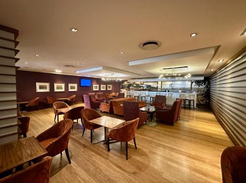 a restaurant with tables and chairs and a bar at Garden Court Nelson Mandela Boulevard in Cape Town