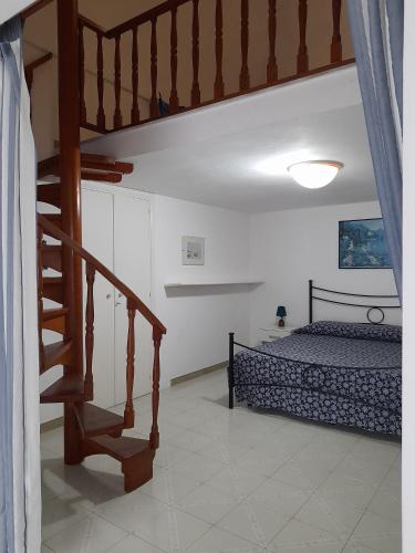 a bedroom with a bed and a wooden staircase at Poseidone Ponza in Ponza