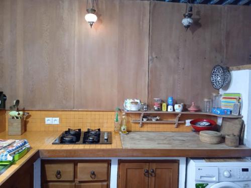 a kitchen with wooden cabinets and a stove top oven at Cozy Home with Mountain View Terraces in Chefchaouene