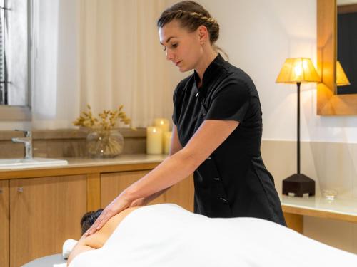 a woman is washing a man on a bed at La Villa Calvi in Calvi