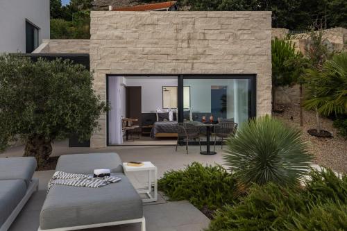 a patio with a couch and a table and chairs at Luxusvilla Marim in Stara Baška