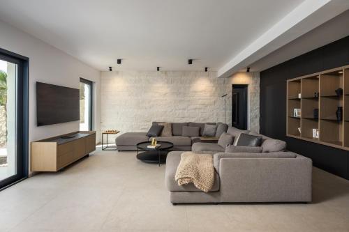 a living room with a couch and a tv at Luxusvilla Marim in Stara Baška