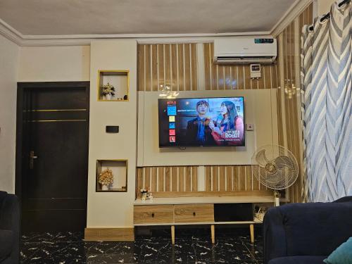 a living room with a flat screen tv on a wall at Homey 2-Bed-Apt 24HRS POWER & Unlimited Internet Access in Lagos