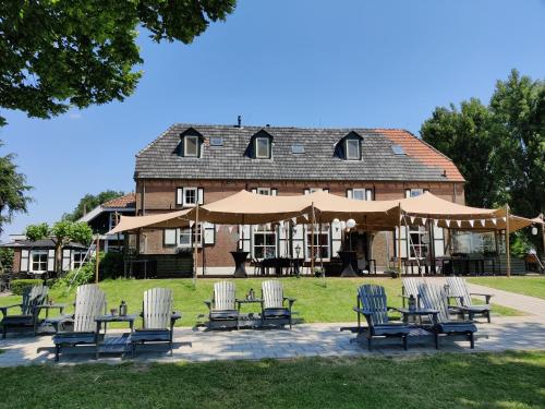 a group of chairs and umbrellas in front of a building at Havezathe Carpe Diem in Vethuizen