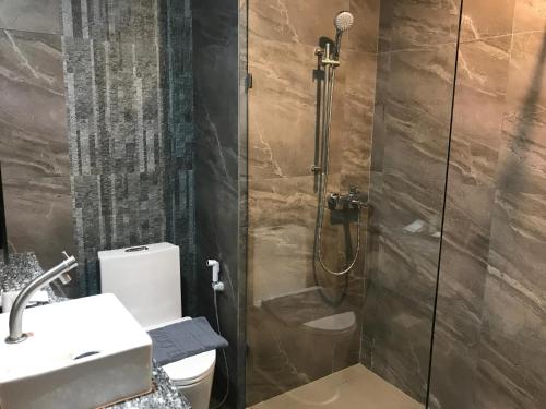 a bathroom with a shower with a toilet and a sink at Bangkok City Link Hotel in Bangkok