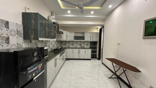 a kitchen with a black and white counter top at Serene Home Islamabad in Islamabad