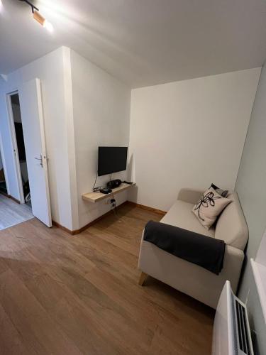 un salon avec un canapé et une télévision dans l'établissement 545 - Amiens, à Amiens