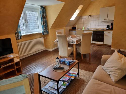 a living room with a table and a kitchen at Ferienhof Bisdorf "Leuchtturm" in Bisdorf