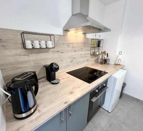 - une cuisine avec un comptoir en bois et une cuisinière dans l'établissement Le chaurien - central et climatisé - local vélo, à Castelnaudary