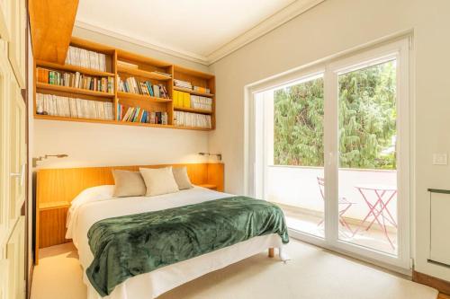 a bedroom with a bed and a large window at Casa da Ribeira in Colares