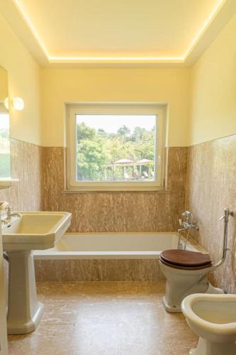 a bathroom with a sink and a toilet and a window at Casa da Ribeira in Colares