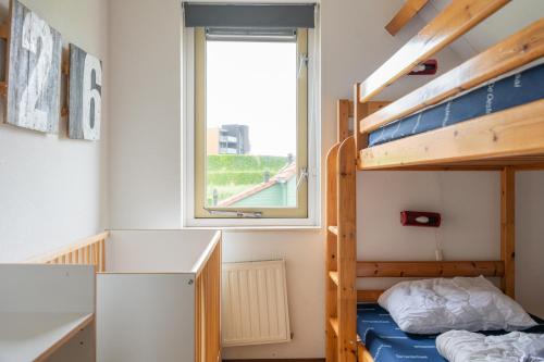 a bedroom with bunk beds and a window at Vakantiewoning in villapark de oesterbaai 113 in Wemeldinge