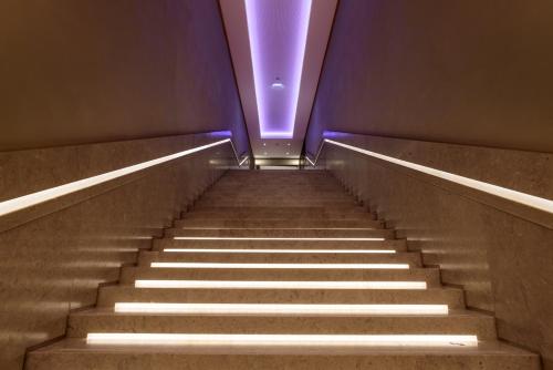 an escalator with a purple light at the top at Áurea Museum by Eurostars Hotel Company in Lisbon