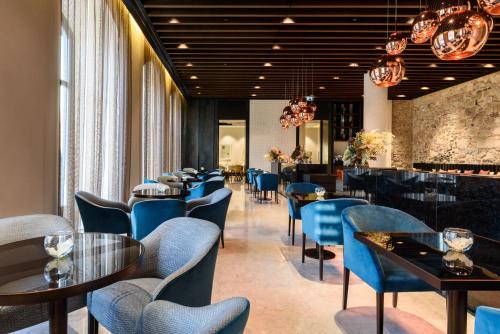 a dining room with blue chairs and tables at Áurea Museum by Eurostars Hotel Company in Lisbon