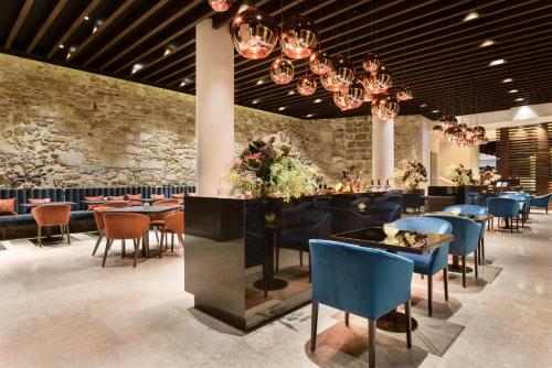 a restaurant with blue chairs and tables and a bar at Áurea Museum by Eurostars Hotel Company in Lisbon