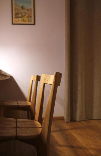 two wooden chairs in a room with a curtain at Nosy Manga - Hotel Ivato Airport in Antananarivo