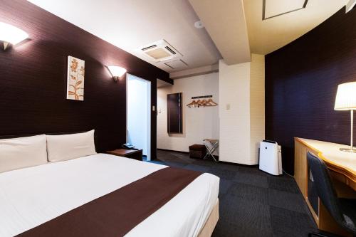 a hotel room with a bed and a desk at Urvest Hotel Kamata in Tokyo