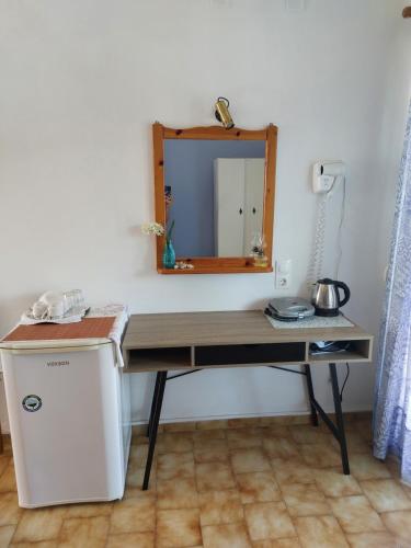 a desk with a mirror in a room at Mirsini Rooms in Votsi