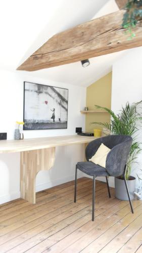 a desk in a living room with a chair at La Galerie, Et Pop Et Chic ! in Poitiers
