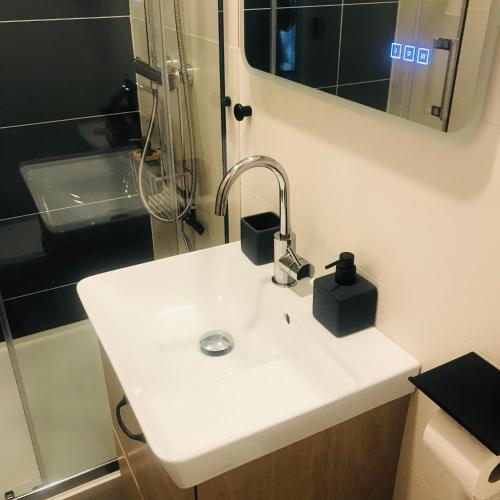 une salle de bain avec un lavabo blanc et un miroir dans l'établissement La Galerie, Et Pop Et Chic !, à Poitiers