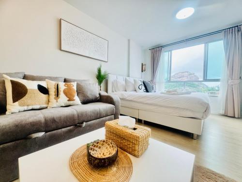 a living room with a couch and a bed at Sea&Mountain view,5 mins walk to famous beach with King size bed in Hua Hin