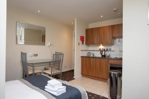 a kitchen and a dining room with a table in a room at Grand Plaza Serviced Apartments in London