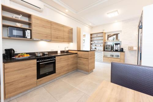 a large kitchen with wooden cabinets and appliances at Maria Theresien Hof Loipersdorf in Jennersdorf