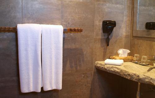 a bathroom with white towels hanging on a wall at Nosy Manga - Hotel Ivato Airport in Antananarivo