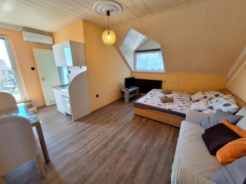 a small room with a bed and a kitchen at Sylvia Apartman in Balatonalmádi
