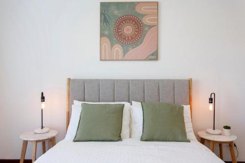 a bedroom with a bed with two side tables at Hillarys Hideaway in Perth
