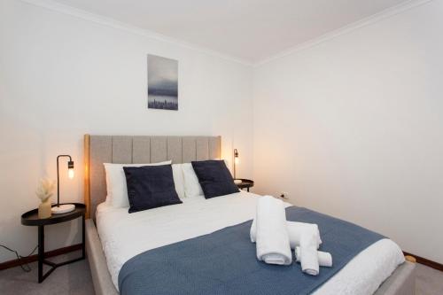 a bedroom with a large bed with towels on it at Hillarys Hideaway in Perth