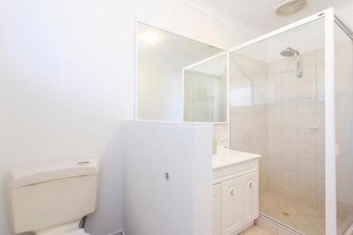 a white bathroom with a toilet and a shower at Hillarys Hideaway in Perth