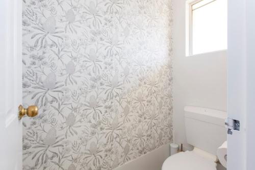 a bathroom with a gray and white floral wallpaper at Hillarys Hideaway in Perth